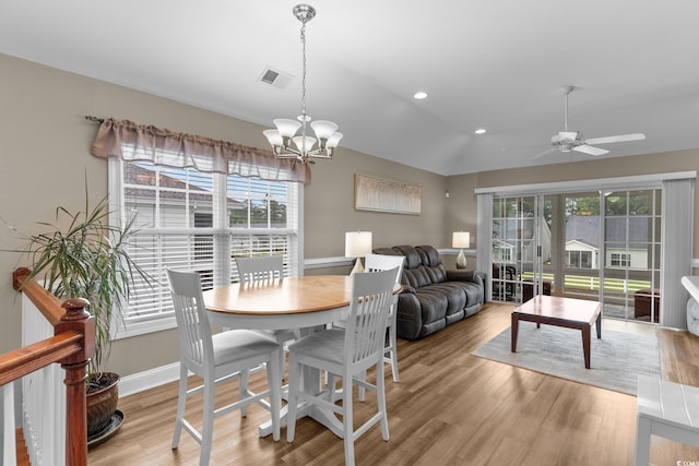 dining space featuring lofted ceiling, ceiling fan with notable chandelier, and light hardwood / wood-style flooring