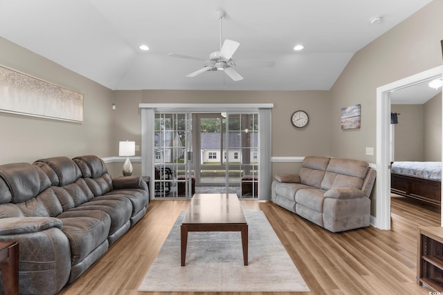 living room with ceiling fan, vaulted ceiling, and light hardwood / wood-style floors