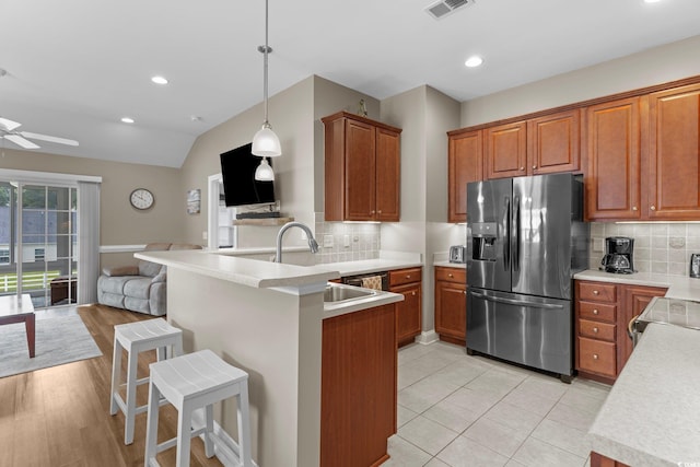 kitchen featuring light wood-type flooring, tasteful backsplash, decorative light fixtures, ceiling fan, and stainless steel fridge with ice dispenser