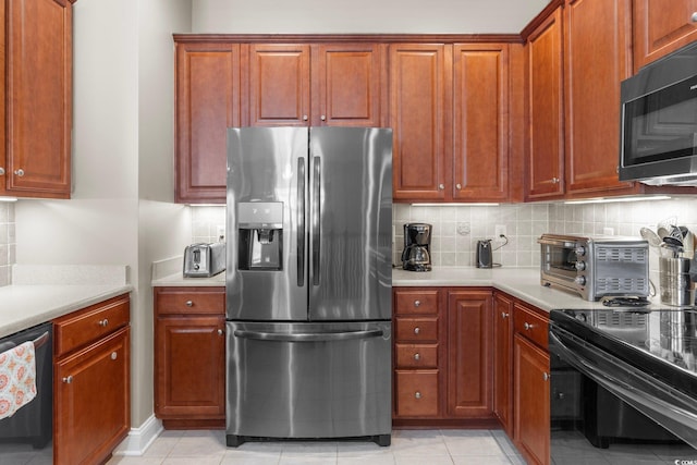 kitchen featuring appliances with stainless steel finishes, light tile patterned floors, and tasteful backsplash