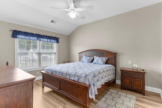 bedroom featuring light wood-type flooring, vaulted ceiling, and ceiling fan