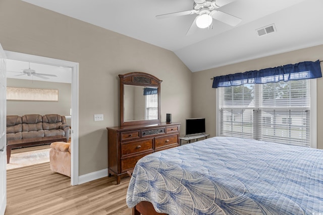 bedroom featuring ceiling fan, light wood-type flooring, and vaulted ceiling