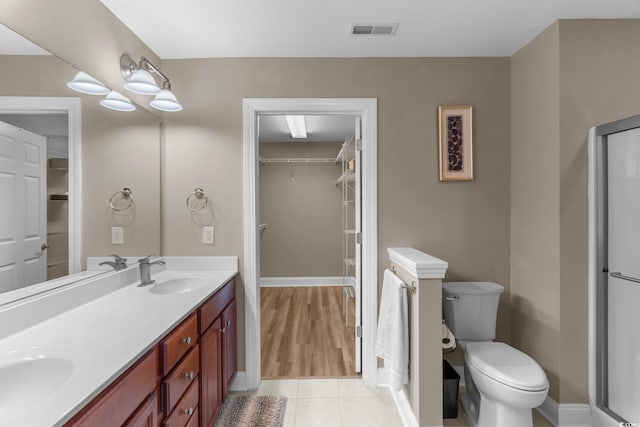 bathroom with vanity, toilet, hardwood / wood-style floors, and an enclosed shower