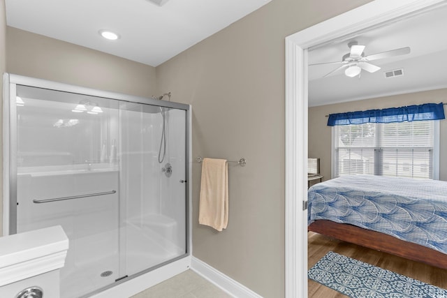 bathroom with wood-type flooring, a shower with door, and ceiling fan