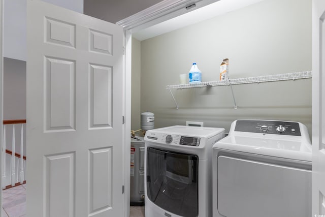 laundry area featuring light tile patterned floors and separate washer and dryer