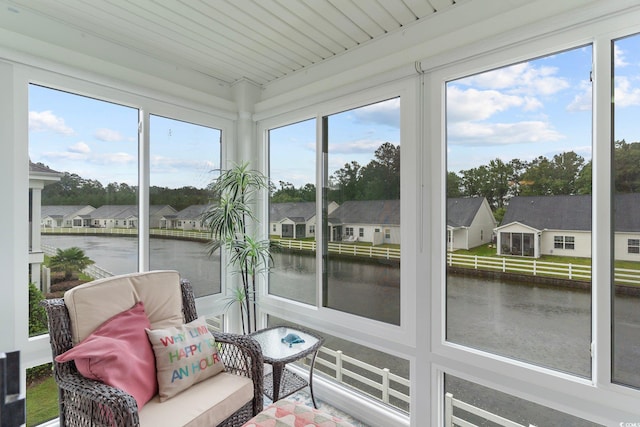 sunroom / solarium featuring a wealth of natural light and a water view