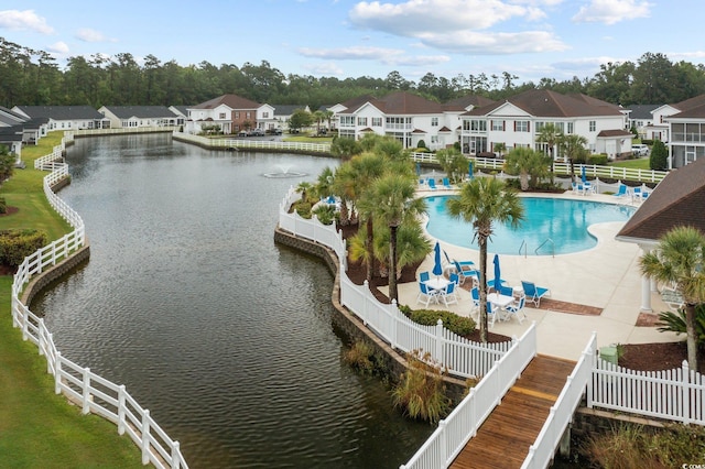 dock area featuring a community pool, a water view, and a patio area