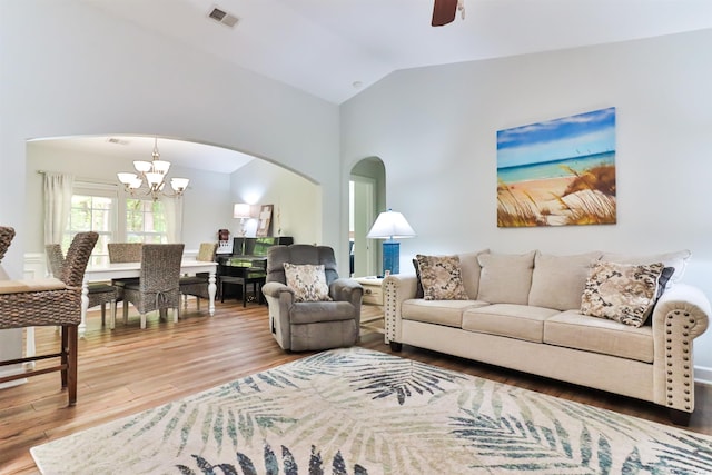 living room featuring wood-type flooring, vaulted ceiling, and ceiling fan with notable chandelier