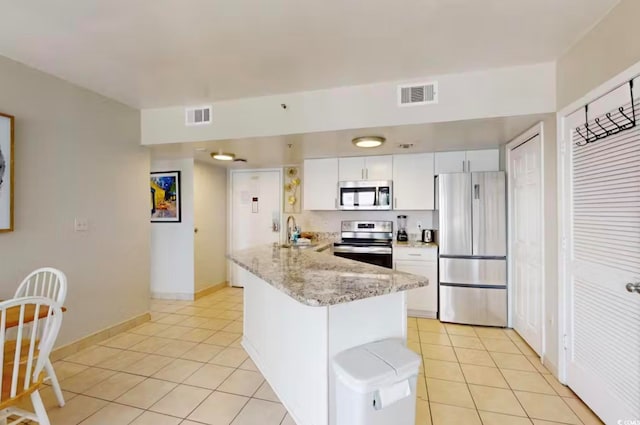 kitchen featuring sink, white cabinets, kitchen peninsula, stainless steel appliances, and light tile patterned floors