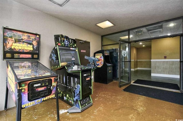 game room featuring a textured ceiling and concrete floors