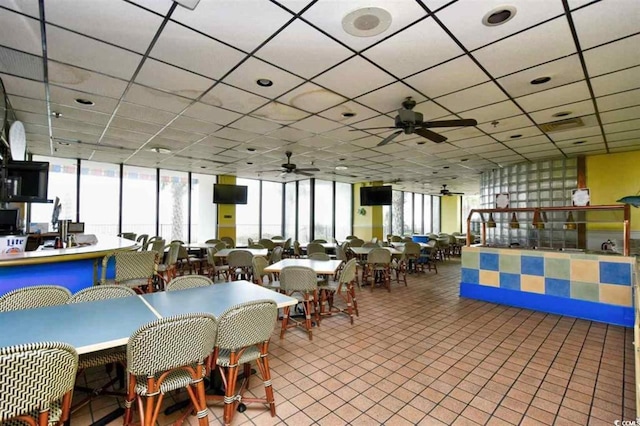 dining room with a paneled ceiling, floor to ceiling windows, and ceiling fan