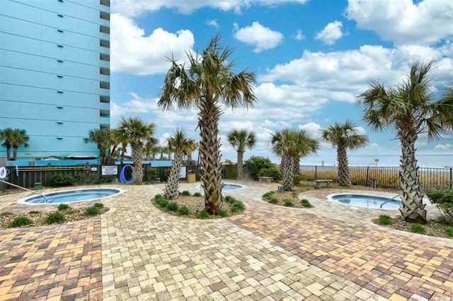 view of pool with a hot tub and a patio area