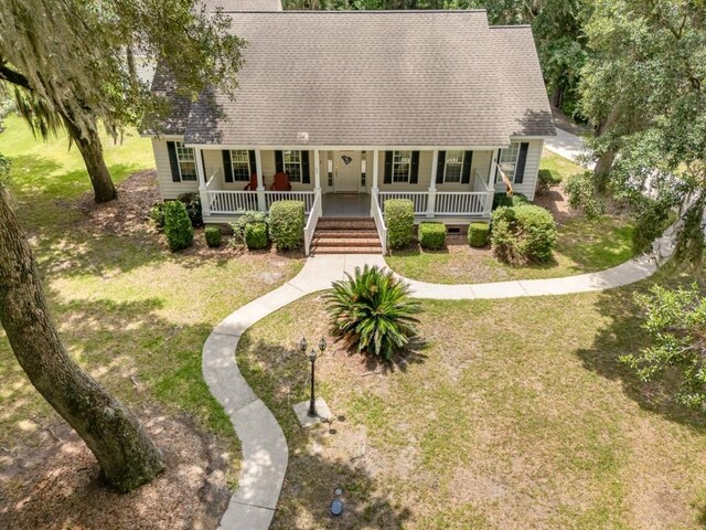 cape cod-style house featuring a porch and a front lawn