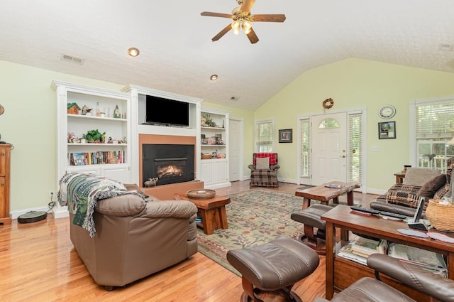 living room featuring ceiling fan, lofted ceiling, and light hardwood / wood-style floors