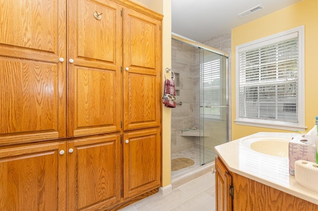 bathroom with walk in shower, tile patterned floors, and vanity