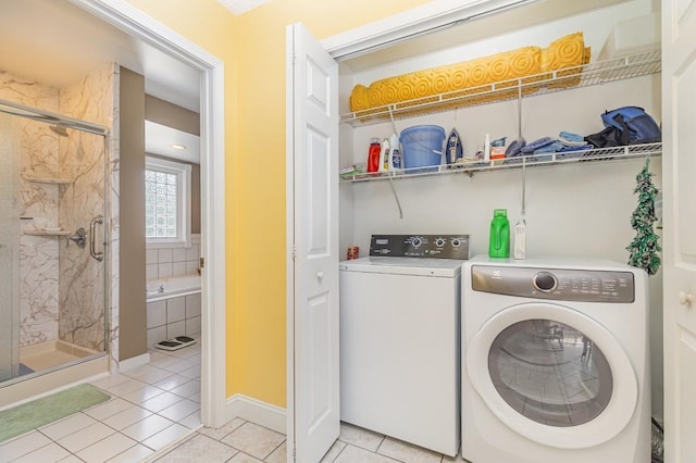 laundry area with light tile patterned flooring and washer and clothes dryer