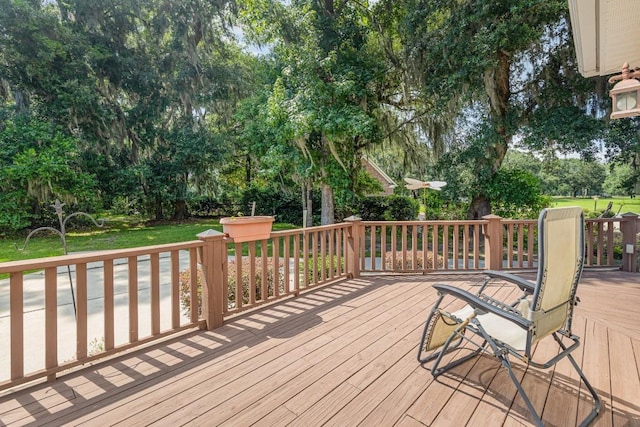 wooden terrace featuring a lawn