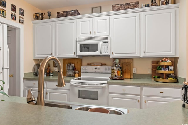 kitchen with white appliances and white cabinetry