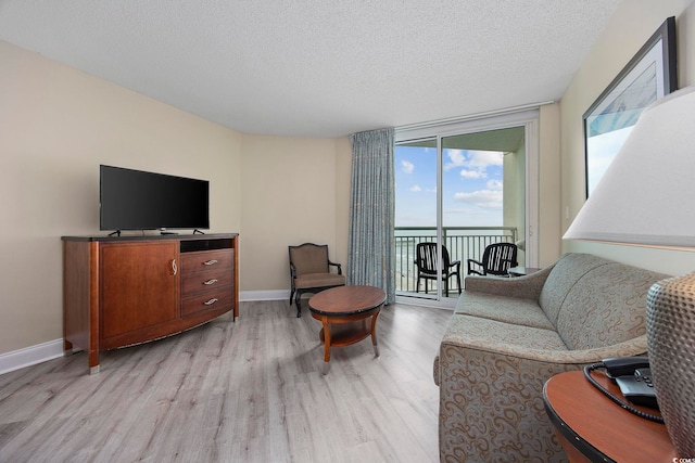 201 S Ocean Blvd Unit 1005, Myrtle Beach, SC 29577 - living room featuring a textured ceiling, floor to ceiling windows, a wealth of natural light, and light wood-style flooring