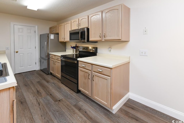 kitchen featuring stainless steel appliances, dark hardwood / wood-style flooring, light brown cabinets, and a textured ceiling