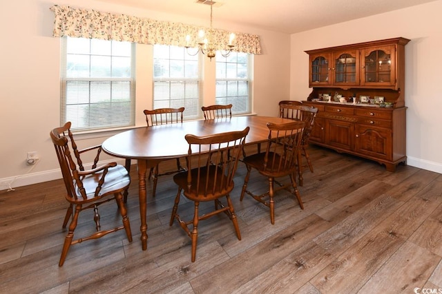 dining room featuring dark hardwood / wood-style flooring and an inviting chandelier