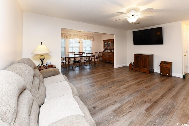 living room with hardwood / wood-style flooring and ceiling fan with notable chandelier