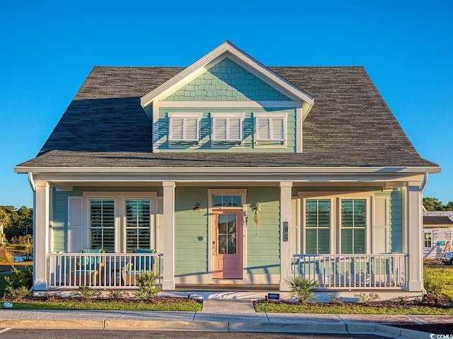 view of front of property featuring a porch and roof with shingles