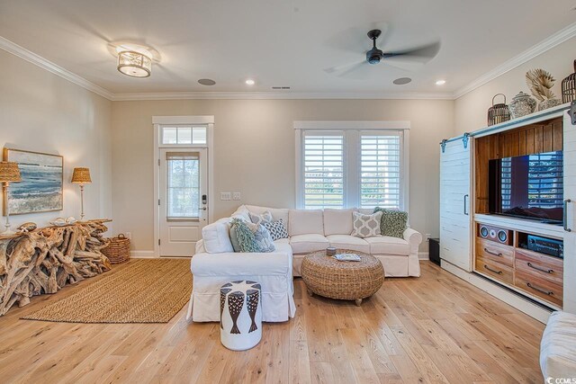 living room with light hardwood / wood-style flooring, crown molding, and ceiling fan