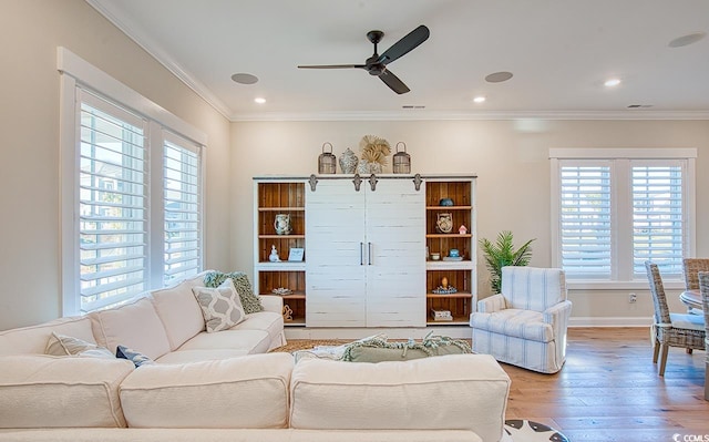 living room featuring ceiling fan, ornamental molding, and light hardwood / wood-style floors