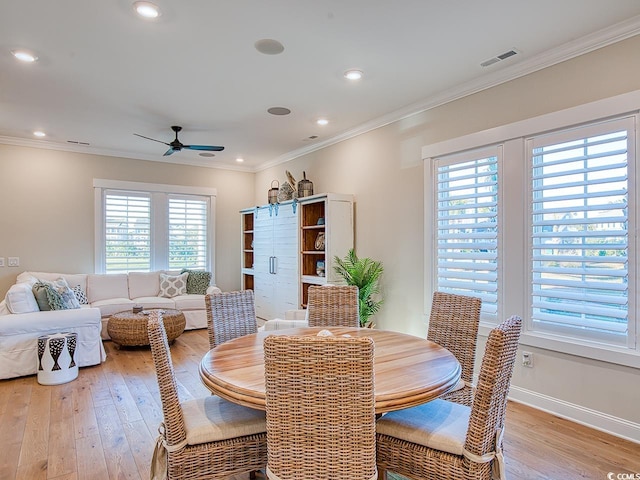 dining space with light wood-type flooring, crown molding, ceiling fan, and a wealth of natural light