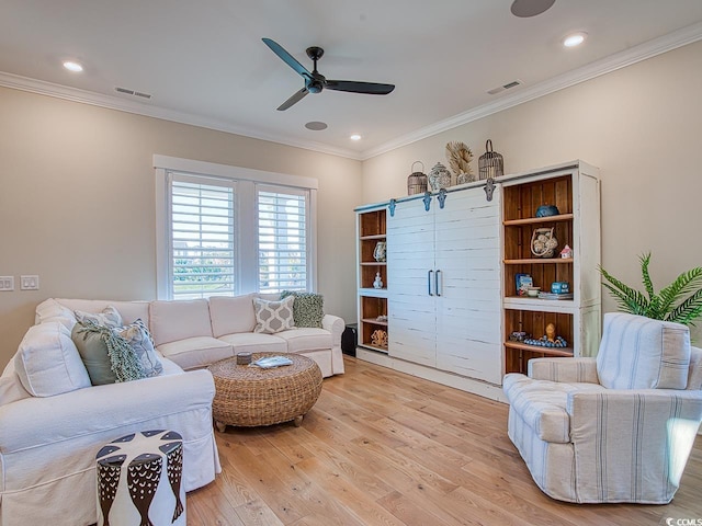 living area with visible vents, a ceiling fan, crown molding, and light wood-style floors