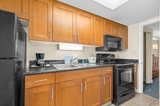 kitchen with light tile patterned floors, sink, and black appliances