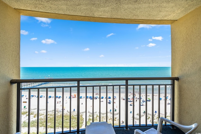 balcony featuring a water view and a beach view