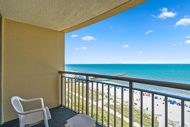 balcony featuring a beach view and a water view