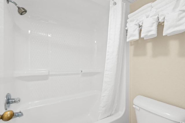 bathroom featuring shower / bath combo with shower curtain and toilet