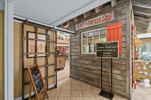 interior space featuring tile patterned flooring and wood walls