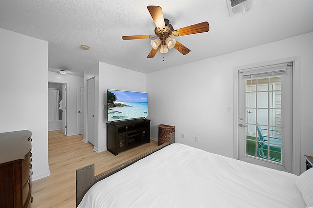 bedroom with light wood-type flooring, ceiling fan, a textured ceiling, and a closet