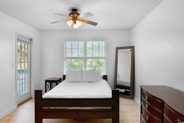 bedroom with multiple windows, a textured ceiling, ceiling fan, and light hardwood / wood-style floors