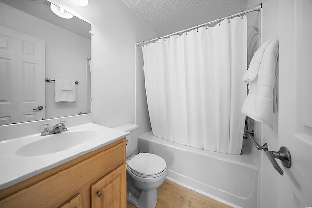 full bathroom with toilet, a textured ceiling, hardwood / wood-style flooring, shower / bath combo, and vanity