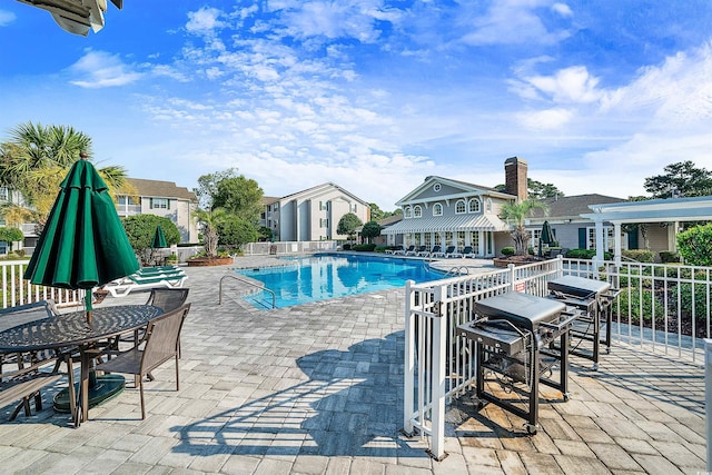 view of swimming pool featuring area for grilling and a patio area