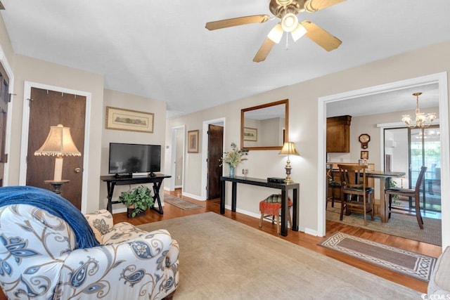 living room featuring ceiling fan with notable chandelier and hardwood / wood-style floors