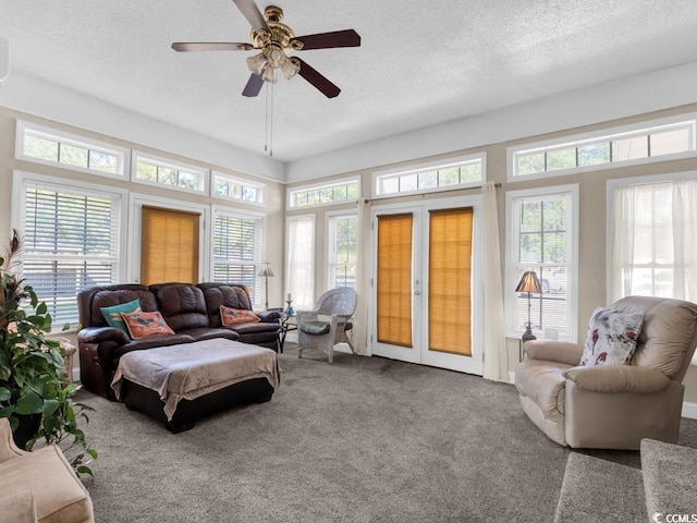 carpeted living room with ceiling fan, a healthy amount of sunlight, a textured ceiling, and french doors