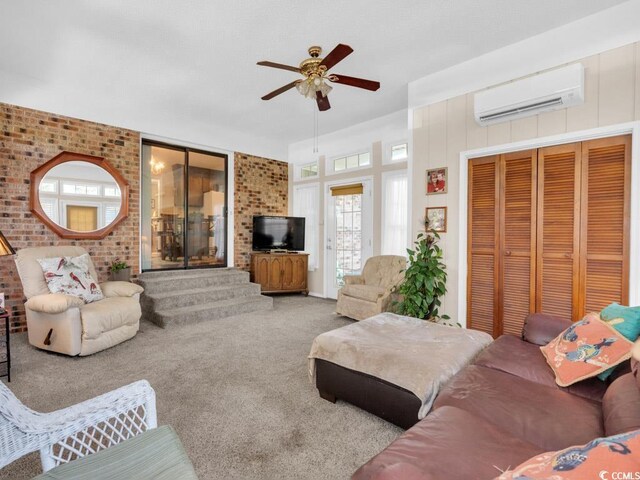 living room with ceiling fan, brick wall, carpet, and an AC wall unit