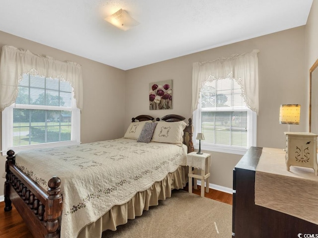 bedroom with hardwood / wood-style flooring and multiple windows