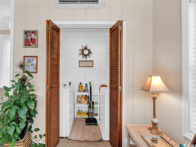 corridor featuring washer / clothes dryer and an AC wall unit