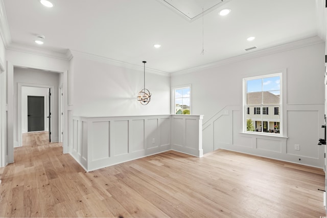 unfurnished room with recessed lighting, visible vents, a decorative wall, attic access, and light wood-type flooring