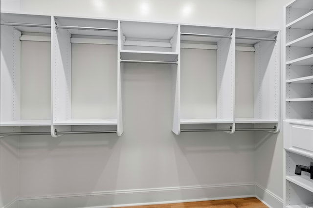 walk in closet with wood finished floors