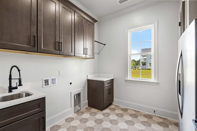 clothes washing area with light tile patterned floors, sink, washer hookup, cabinets, and ornamental molding