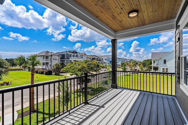 wooden terrace with a residential view and a yard