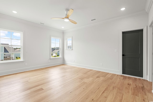 spare room with ornamental molding, light wood-style flooring, and visible vents